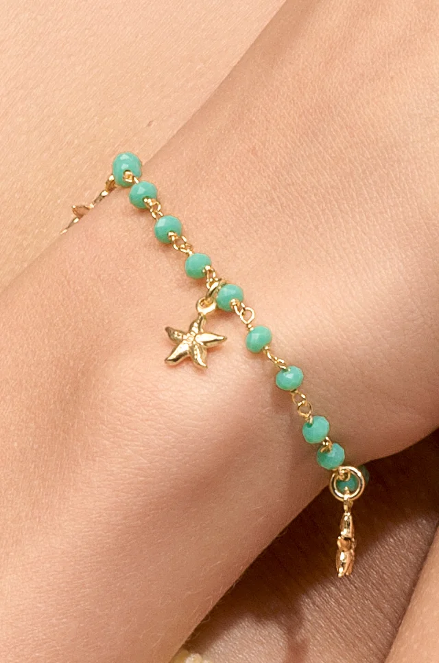 Modelo luciendo pulsera de estrellas de mar bañada en oro